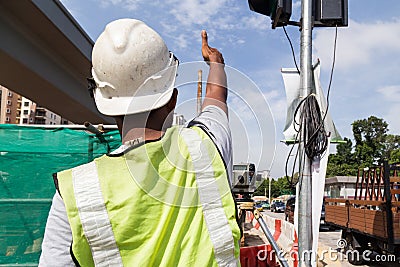 Surveyor gesturing after taking readings of dumpy automatic level instrument Editorial Stock Photo