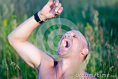 Survival in the wild. Hungry man wants to eat a lizard. Stock Photo