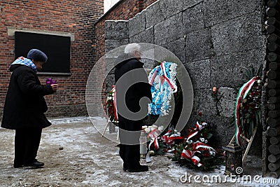 Survived prisoners fold flowers by the wall of death Editorial Stock Photo