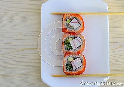 Sushi a dish of traditional Japanese cuisine cooked from rice, calves of a salmon, crabmeat, avocado and a cucumber. Stock Photo