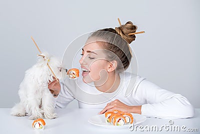 Sushi. Fashion portrait of beauty model girl eating sushi rolls, japanese food. Beautiful woman holding chopsticks with Stock Photo