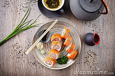Sushi maki rolls with spicy crab, salmon, cucumber on a plate with chopsticks, soy sauce, wasabi and ginger. Japanese Stock Photo
