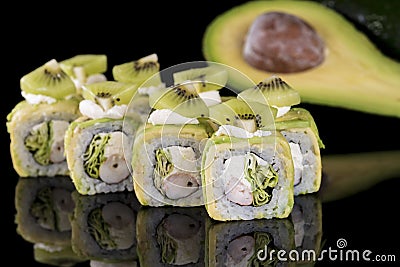 Sushi Roll with crab meat, kiwi and avocado over black backgrou Stock Photo