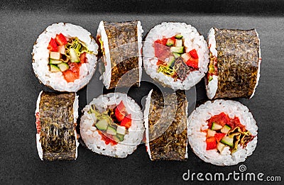 Sushi Roll - Maki Sushi with pepper, cucumber, tomato and cabbage on black plate Stock Photo