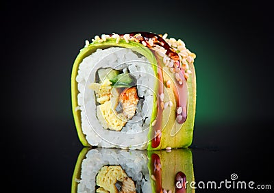 Sushi roll over black background. Sushi roll with eel, tofu, vegetables and avocado closeup Stock Photo