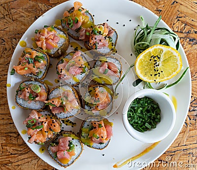 Sushi roll plate with salmon, ciboulette and mango salsa Stock Photo