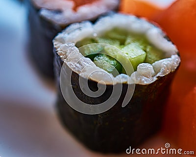 Sushi roll of rice wrapped with seaweed and a filling of green cucumber, maki Stock Photo