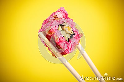 Sushi rolls close-up in wooden sticks on a bright yellow gradient background Stock Photo