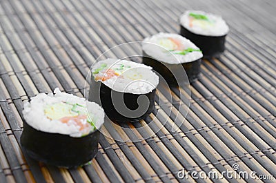 Sushi rolls lies on a bamboo straw serwing mat. Traditional Asian food Stock Photo