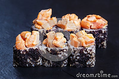 Sushi rolls topped with torched salmon and black caviar served Stock Photo