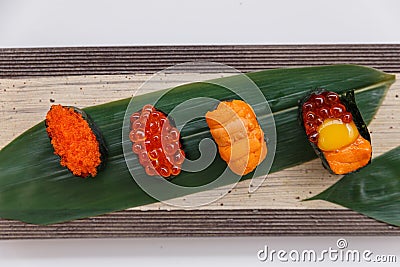 Sushi Set Include Tobiko, Ikura, Sea Urchin and Ikura, Urchin and Quail Egg Yolk Served on Leaf on Stone Plate Stock Photo