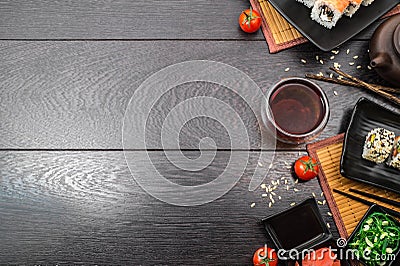 Sushi set sashimi and sushi rolls and tomatoes on dark background Stock Photo