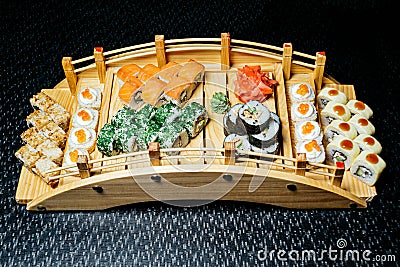 Sushi set on a wooden bridge on a black table Stock Photo