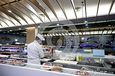 Sushi on a sliding rail and Japanese food chef in a Japanese restaurant in a shopping mall at Sukhumvit road Bangkok Thailand Editorial Stock Photo
