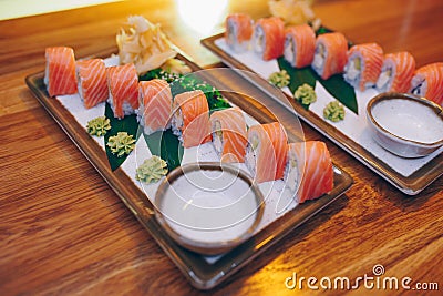 Sushi Smoked Philly plateau buffet in night dining resturant flat lay. Delicious Philadelphia salmon flesh seaweed and ginger. Rol Stock Photo