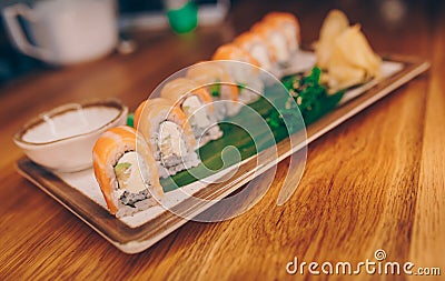 Sushi Smoked Philly plateau buffet in night dining resturant flat lay. Delicious Philadelphia salmon flesh seaweed and ginger. Rol Stock Photo