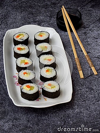 Sushi on white plate, grey background. Traditional Asian food. Diet healthy food. Stock Photo