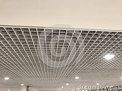 Suspended false ceiling design architectural with macro grid sizes in small for an large space commercial building interior Stock Photo