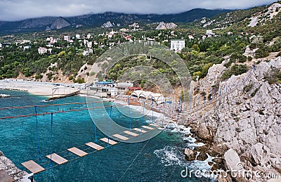 Suspension bridge to Diva rock, Black Sea coast, near Yalta, Crimea. Panorama of the town of Simeiz Stock Photo