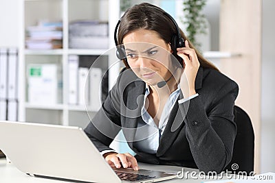 Suspicious telemarketer looking at laptop in the office Stock Photo