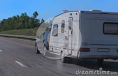 SUV with a camping trailer is moving along the road Stock Photo