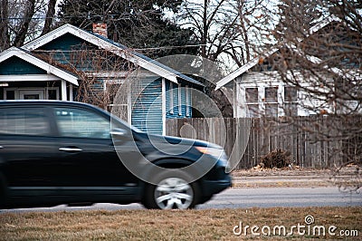 SUV driving through a small town Stock Photo