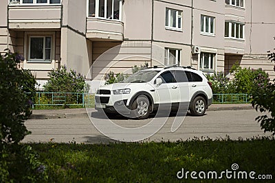 The SUV is parked. A white car stands on the street Stock Photo