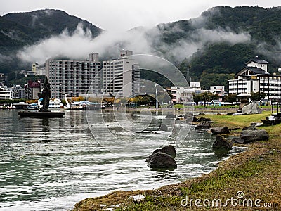 Rainy day at Suwa Lakeside Park with heavy clouds covering the mountains around Lake Suwako Editorial Stock Photo
