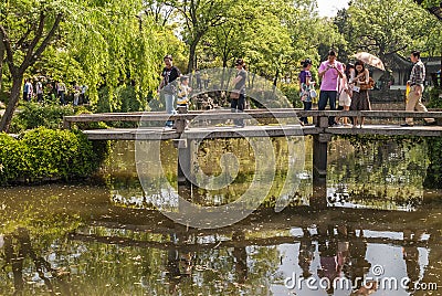 People on bridge over pond at Humble Administrators garden, Suzhou, China Editorial Stock Photo