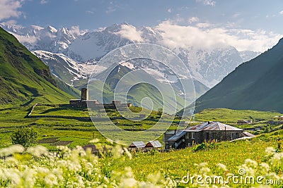 Svaneti watch tower in Ushguli village with Shkhara mountain in a morning, Caucasus mountain range, Georgia Stock Photo