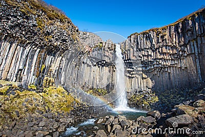 Svartifoss in midday no clounds in Iceland with rainbow Stock Photo