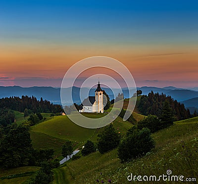 Sveti Andrej, Slovenia - Saint Andrew church Sv. Andrej at sunset in Skofja Loka area with Julian Alps and colorful sky Stock Photo