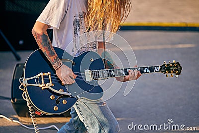 Rock musician playing guitar at outdoor heavy metal grunge festival, strum guitar, rock performance Editorial Stock Photo