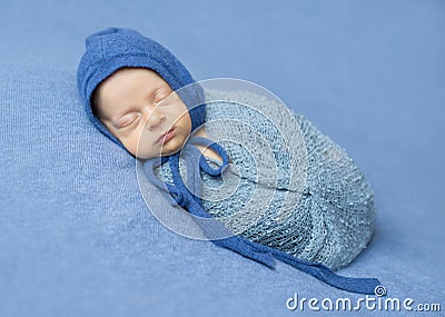 Swaddled newborn sleeping with hood on his head Stock Photo