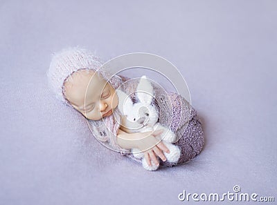 Swaddled sleeping newborn with toy in hand Stock Photo