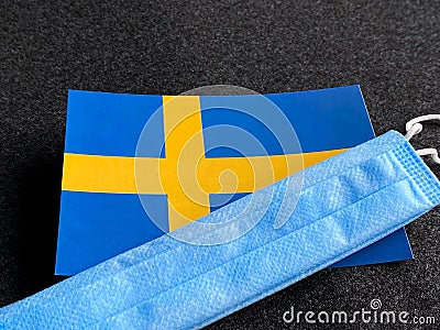 Sweden, Swedish flag is near a blue mask on the dark gray background. Tourist trip. European Football Championship Stock Photo