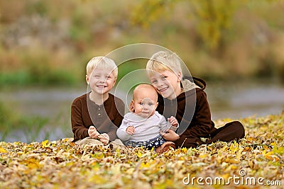 Swee Happy Children Sitting in Fallen Leaves Stock Photo