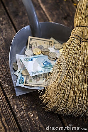 Sweep the money with a broom to collect in the scoop Stock Photo