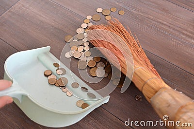 Sweeping money in a scoop with a broom Stock Photo