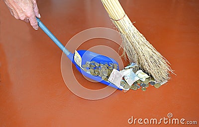 Sweeping small money on the red floor. Stock Photo