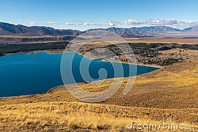 Sweeping views of the spectacular golden Mackenzie Basin from the top of Mt John including Lake Tekapo Stock Photo