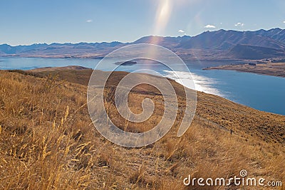 Sweeping views of the spectacular golden Mackenzie Basin from the top of Mt John including Lake Tekapo Stock Photo