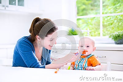 Sweet baby boy eating his first solid food witn hi Stock Photo