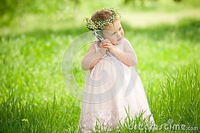 Sweet baby girl outdoors with a bouquet of lilies Stock Photo