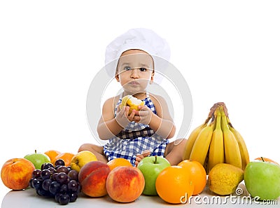 Sweet beautiful baby cook eating healthy fruits Stock Photo