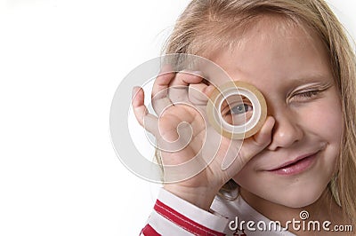 Sweet beautiful female child with blue eyes holding adhesive transparent tape school supplies Stock Photo