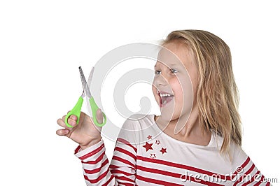 Sweet beautiful female child 6 to 8 years old holding cutting scissors school supplies concept Stock Photo