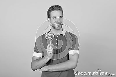 Sweet boy. Taste of childhood. Happy eating sweets. Symbol of happiness. Man eat lollipop. Man smiling hold lollipop Stock Photo