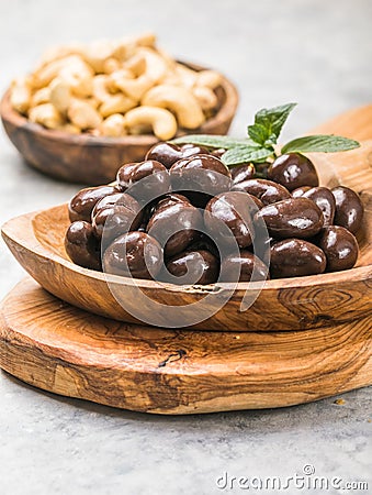 Sweet cashew and chocolate covered nuts on gray stone background Stock Photo