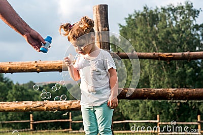 Sweet child child trying to catch soap bubble.Summer in the village. Warm sunset. Happy childhood Stock Photo